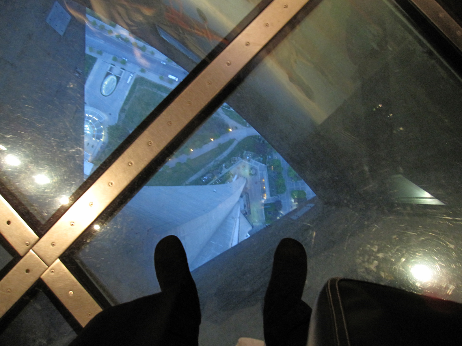 Looking straight down through the structural glass floor panels to the street below