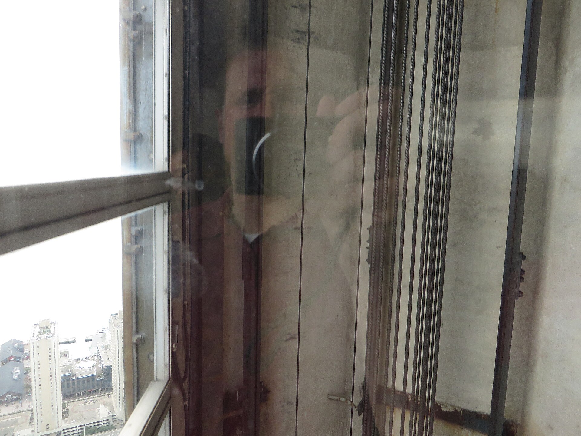 Inside an observation elevator car looking along the hoistway
